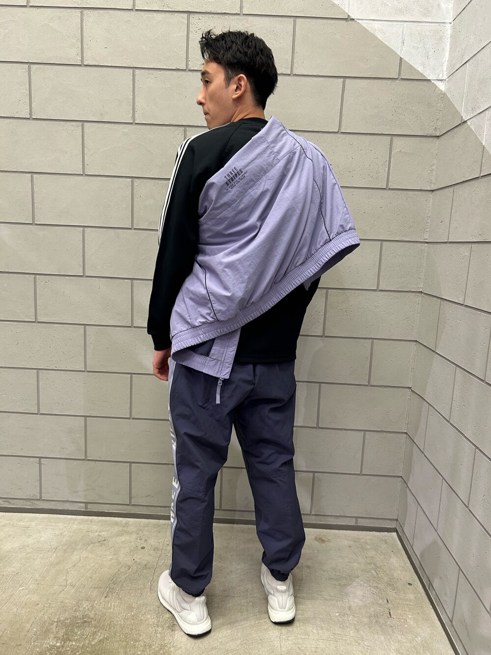 ホワイト系のスニーカー、ブルー系のパンツ、パープル系のトップスを着用したメンズの秋コーディネートの2枚目の写真