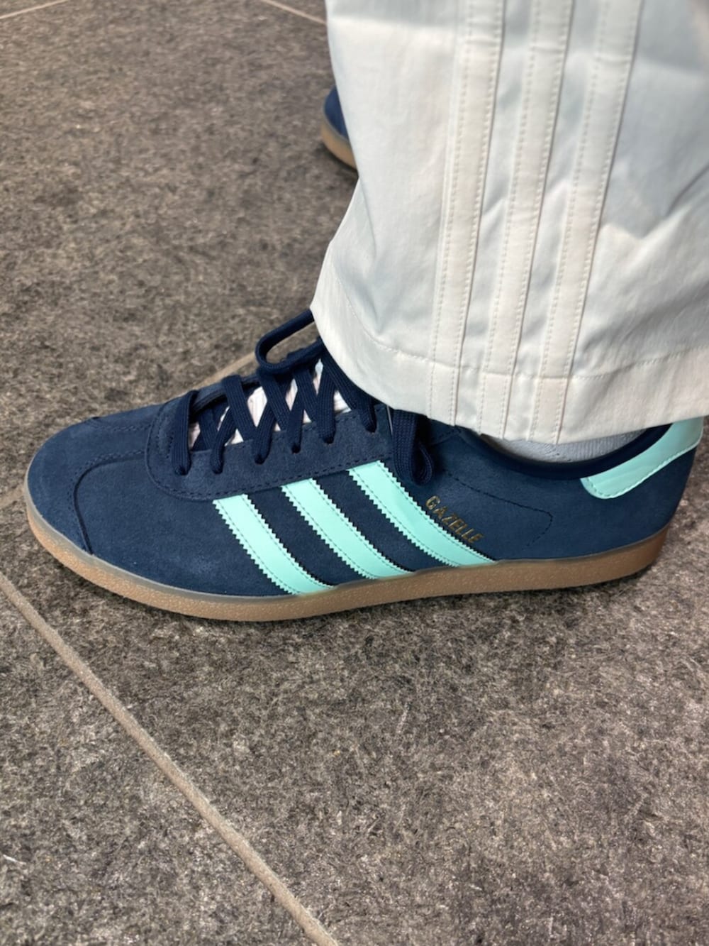 ホワイト系のその他パンツ、ホワイト系のポロシャツ、ブルー系のスニーカーを着用したメンズの冬コーディネートの2枚目の写真