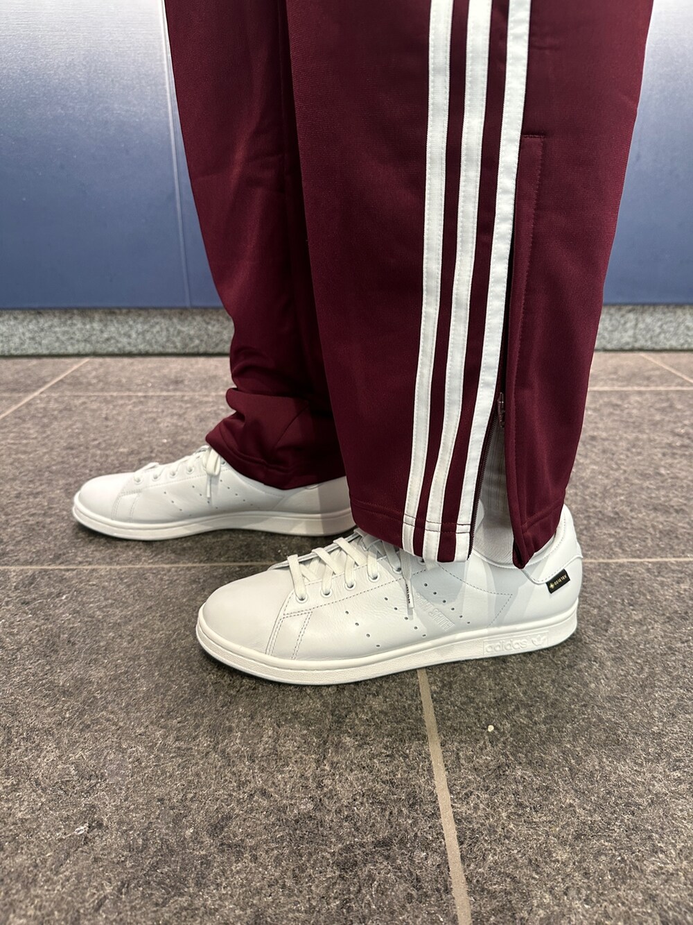 ホワイト系のスニーカー、レッド系のジャージ、レッド系のスウェットパンツを着用したメンズの夏コーディネートの3枚目の写真