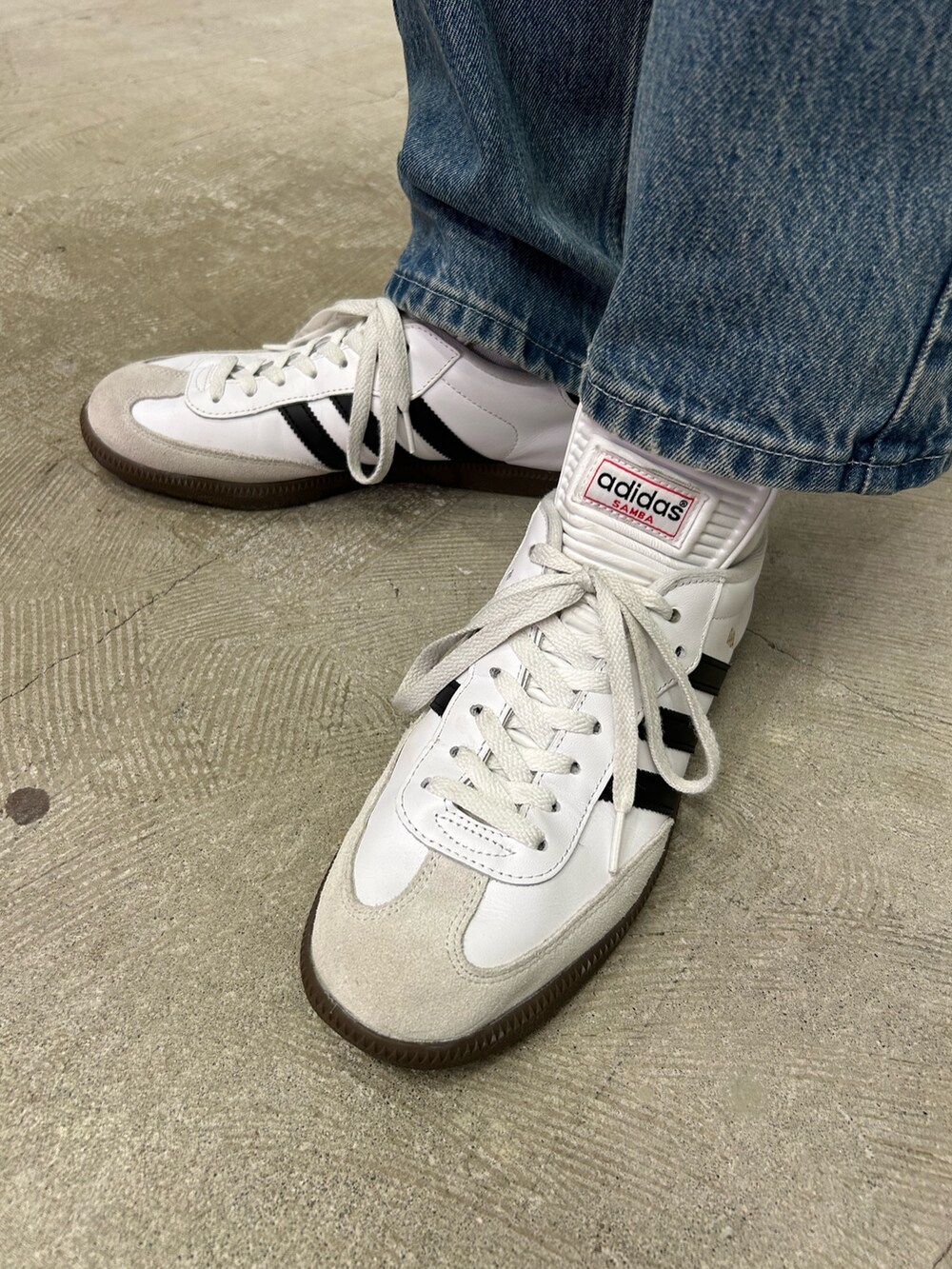 ホワイト系のスニーカー、グリーン系のトップスを着用したメンズの秋コーディネートの2枚目の写真