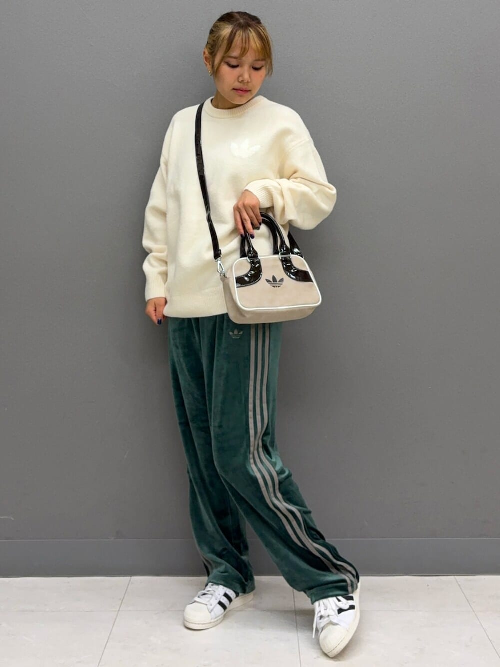 ホワイト系のシューズ、ホワイト系のニット/セーター、グリーン系のその他パンツを着用したレディースの秋コーディネートの2枚目の写真