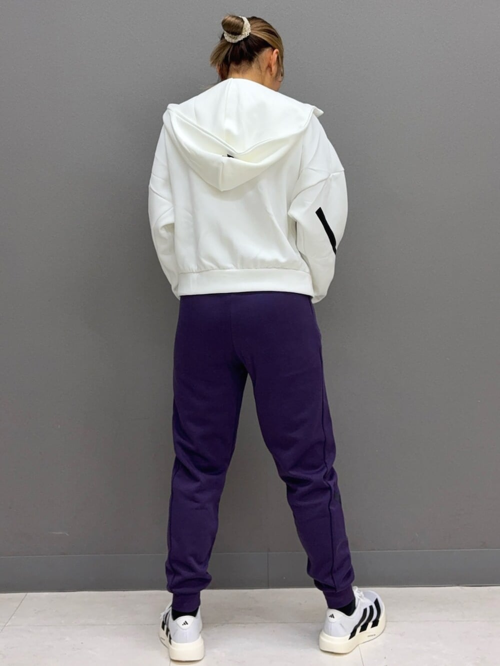 ホワイト系のシューズ、ホワイト系のパーカー、パープル系のその他パンツを着用したレディースの秋コーディネートの2枚目の写真