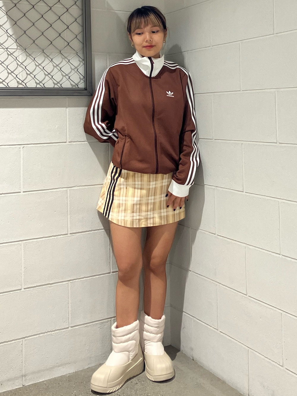 ブラウン系のジャージ、ベージュ系のスカート、ベージュ系のスニーカーを着用したレディースの秋コーディネートの2枚目の写真