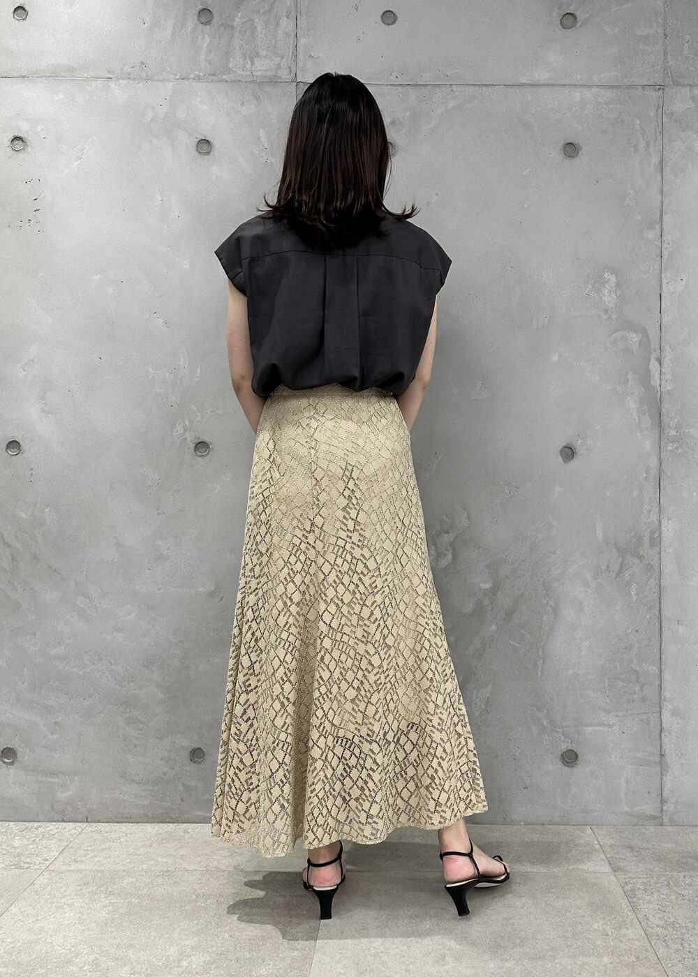 ブラック系のハンドバッグ、ブラック系のサンダル、ブラウン系のシャツ/ブラウスを着用したレディースの夏コーディネートの3枚目の写真