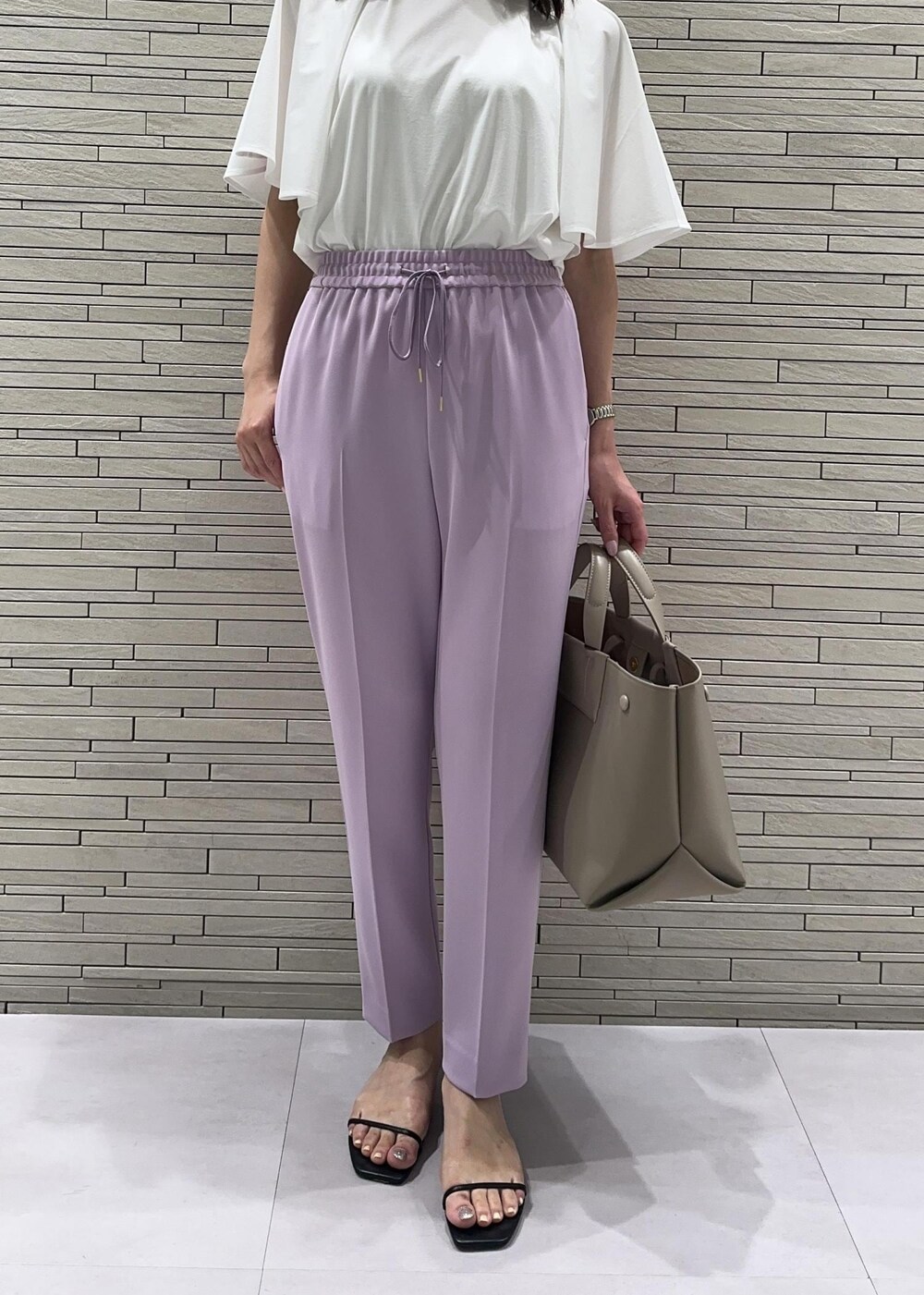 ベージュ系のハンドバッグ、ブラック系のサンダル、パープル系のその他パンツを着用したレディースの夏コーディネートの5枚目の写真