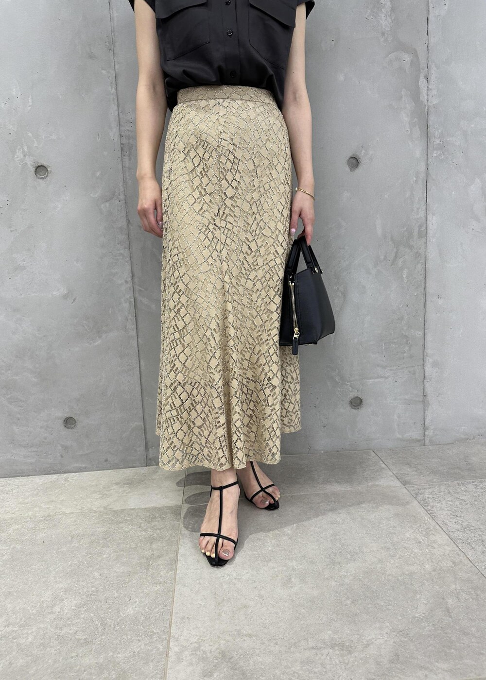 ブラック系のハンドバッグ、ブラック系のサンダル、ブラウン系のシャツ/ブラウスを着用したレディースの夏コーディネートの5枚目の写真