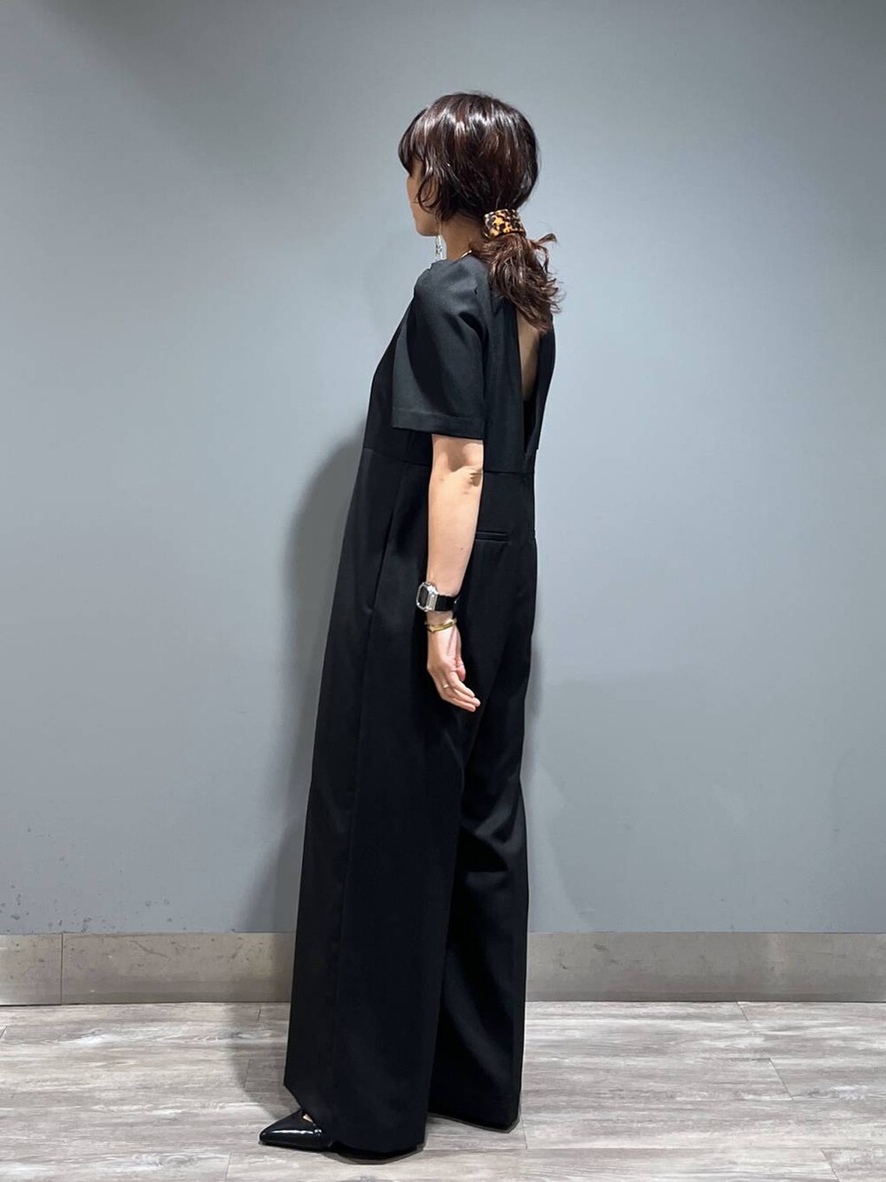 ブラック系のパンプス、ベージュ系のショルダーバッグ、ブラック系のつなぎ/オールインワンを着用したレディースの秋コーディネートの5枚目の写真