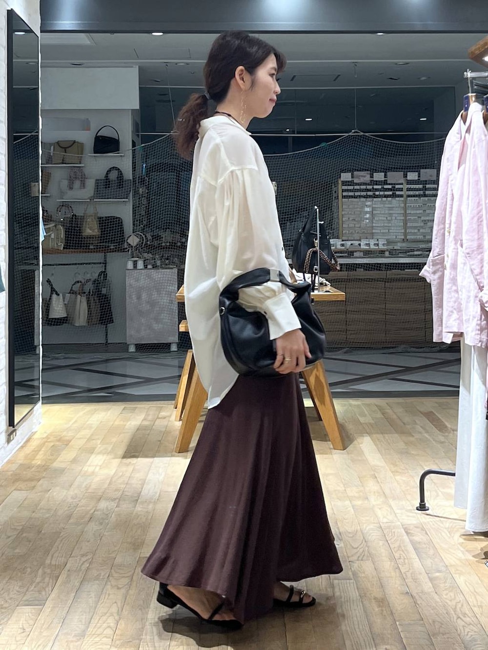 ホワイト系のシャツ/ブラウス、ブラック系のハンドバッグ、ブラック系のサンダルを着用したレディースの春コーディネートの2枚目の写真