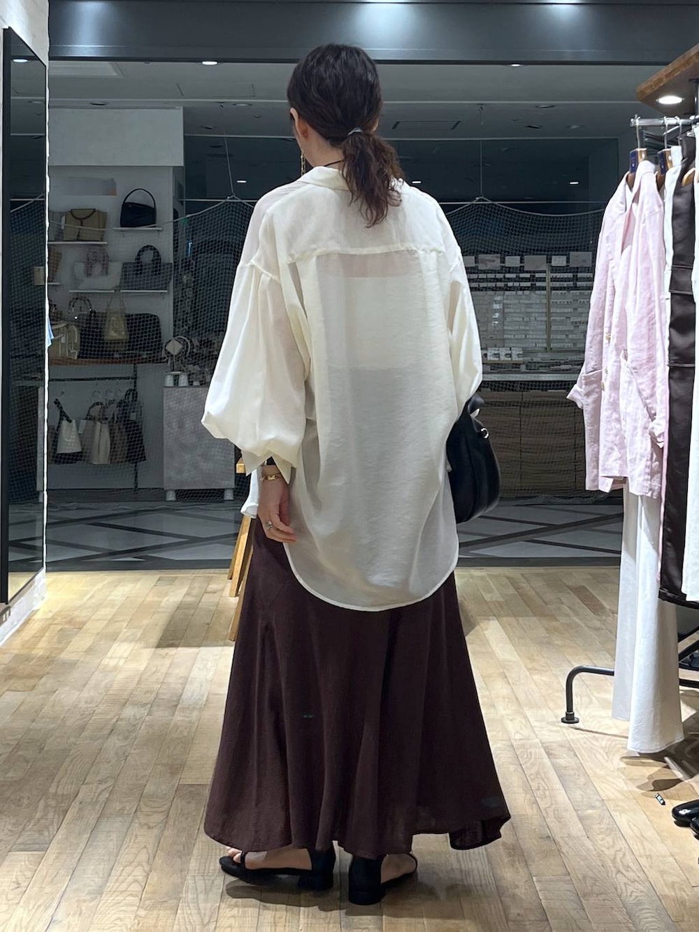 ホワイト系のシャツ/ブラウス、ブラック系のハンドバッグ、ブラック系のサンダルを着用したレディースの春コーディネートの3枚目の写真