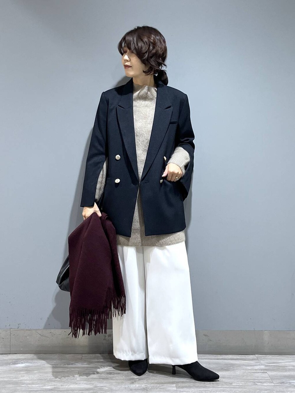 イエロー系のワンピース、ホワイト系のスラックス、ブルー系のテーラードジャケットを着用したレディースの秋コーディネートの7枚目の写真