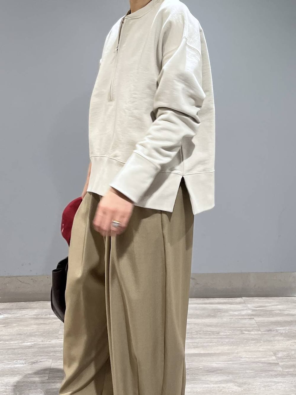 ベージュ系のスラックス、ブラック系のパンプス、ブラウン系のショルダーバッグを着用したレディースの冬コーディネートの4枚目の写真