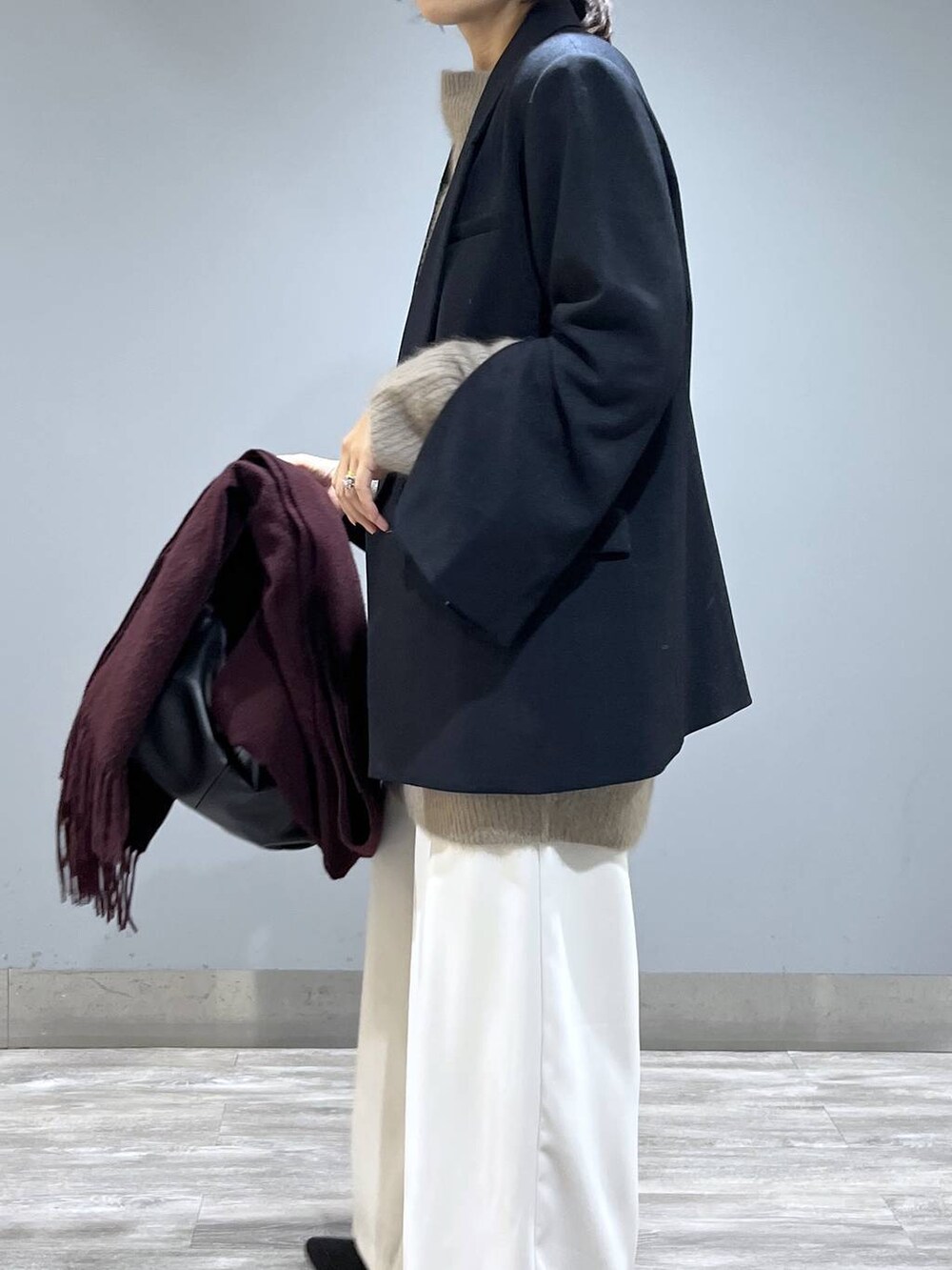 イエロー系のワンピース、ホワイト系のスラックス、ブルー系のテーラードジャケットを着用したレディースの秋コーディネートの6枚目の写真