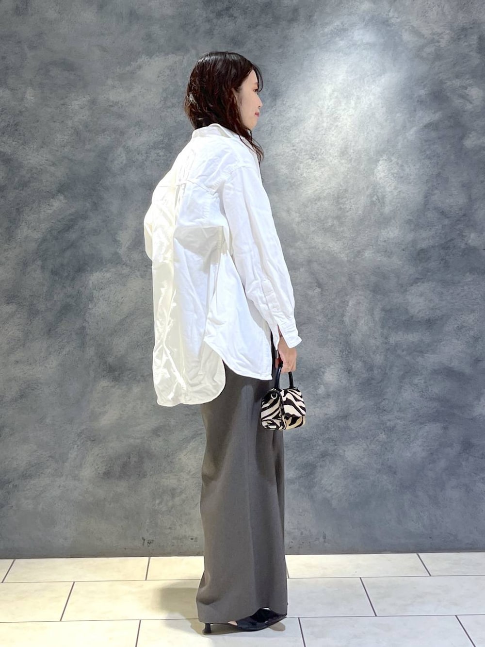 ブラック系のパンプス、ホワイト系のシャツ/ブラウス、グレー系のつなぎ/オールインワンを着用したレディースの春コーディネートの2枚目の写真