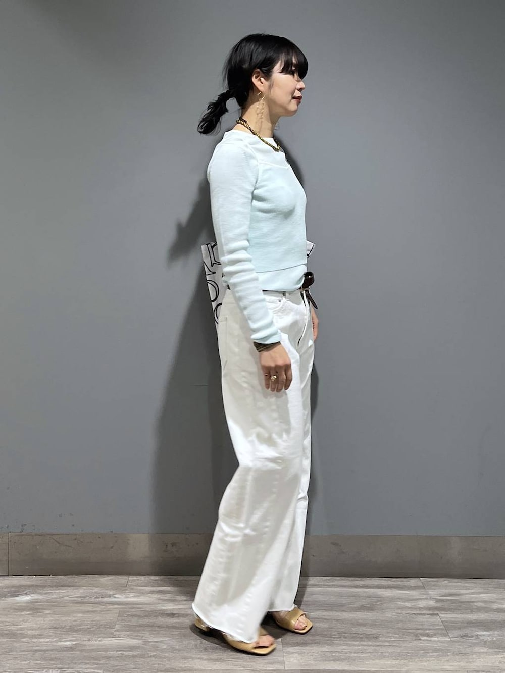 ホワイト系のデニムパンツ、ブルー系のTシャツ/カットソー、ベージュ系のサンダルを着用したレディースの春コーディネートの2枚目の写真