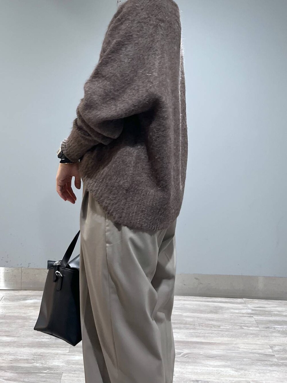 ブラウン系のニット/セーター、ブラック系のショルダーバッグ、ブラック系のブーツを着用したレディースの秋コーディネートの5枚目の写真