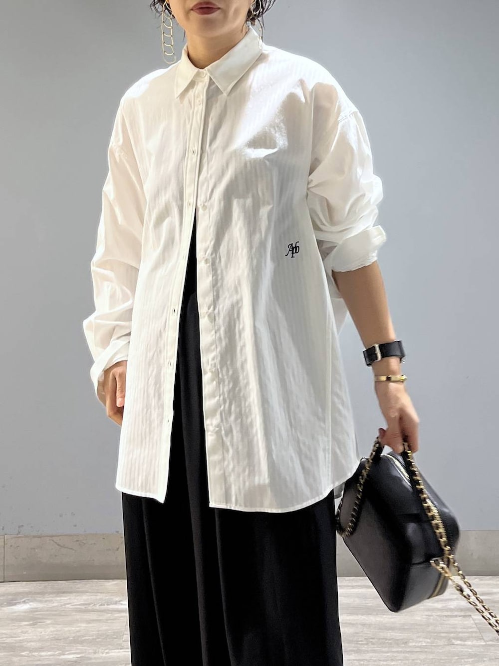 ブラック系のスラックス、ホワイト系のシャツ/ブラウス、ブラック系のショルダーバッグを着用したレディースの冬コーディネートの6枚目の写真