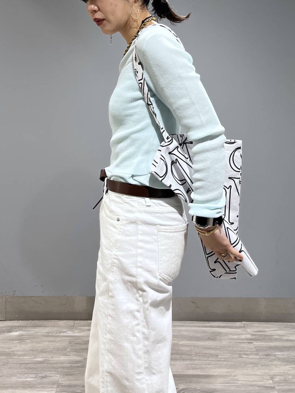 ホワイト系のデニムパンツ、ブルー系のTシャツ/カットソー、ベージュ系のサンダルを着用したレディースの春コーディネートの5枚目の写真