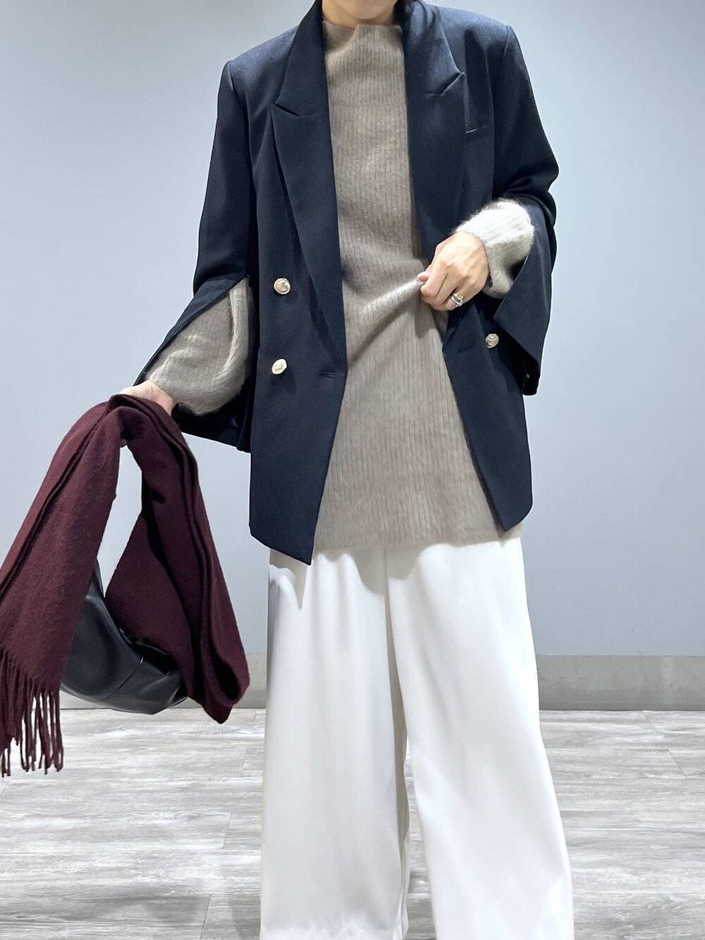 イエロー系のワンピース、ホワイト系のスラックス、ブルー系のテーラードジャケットを着用したレディースの秋コーディネートの5枚目の写真