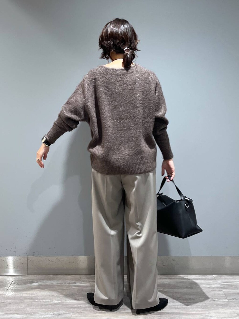 ブラウン系のニット/セーター、ブラック系のショルダーバッグ、ブラック系のブーツを着用したレディースの秋コーディネートの3枚目の写真