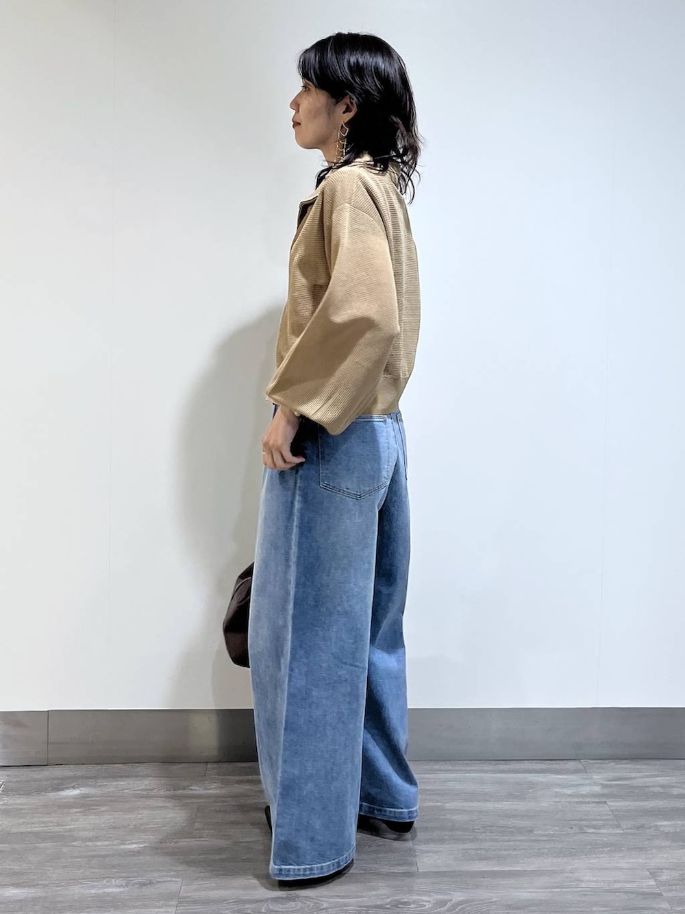 ベージュ系のブルゾン、ブラック系のパンプス、レッド系のTシャツ/カットソーを着用したレディースの夏コーディネートの3枚目の写真