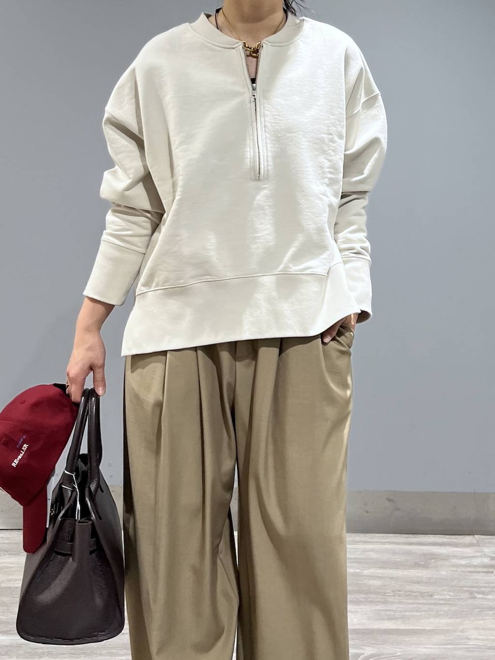 ベージュ系のスラックス、ブラック系のパンプス、ブラウン系のショルダーバッグを着用したレディースの冬コーディネートの5枚目の写真