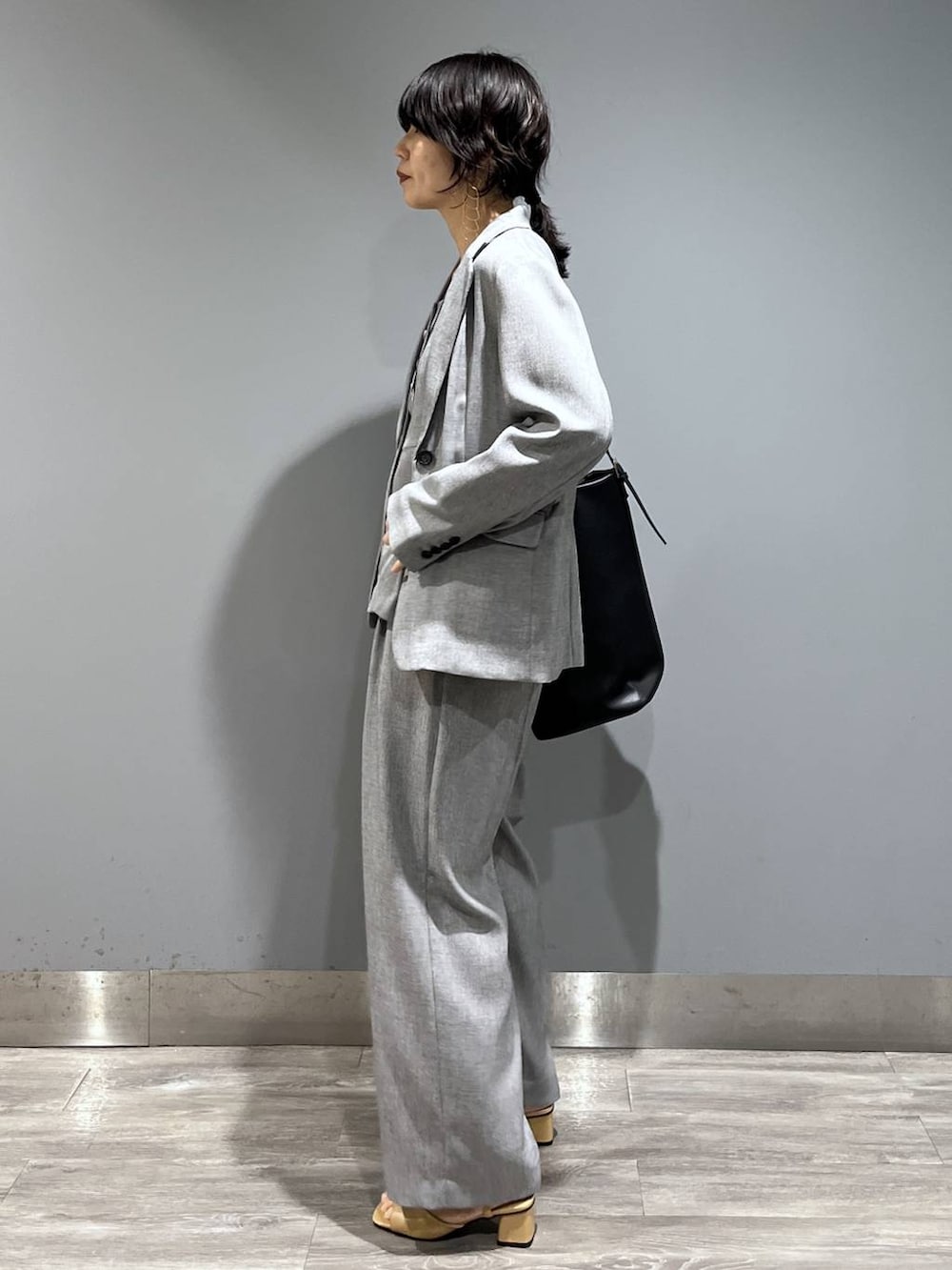 ブラック系のトートバッグ、ブラック系のノーカラージャケット、ブラック系のベストを着用したレディースの春コーディネートの4枚目の写真