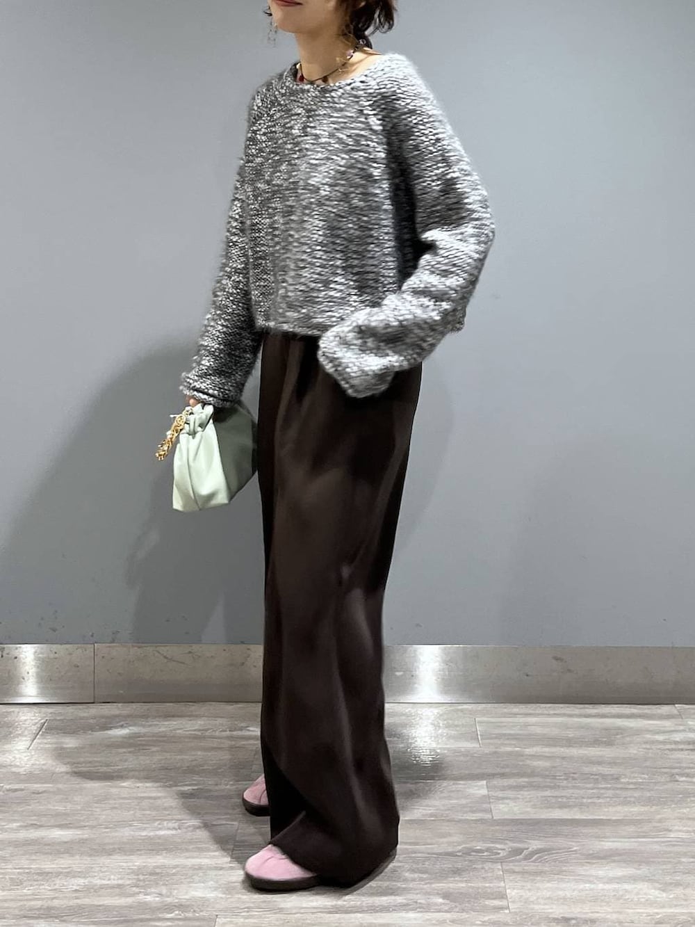 ブラウン系のスラックス、グリーン系のショルダーバッグ、グレー系のニット/セーターを着用したレディースの冬コーディネートの7枚目の写真