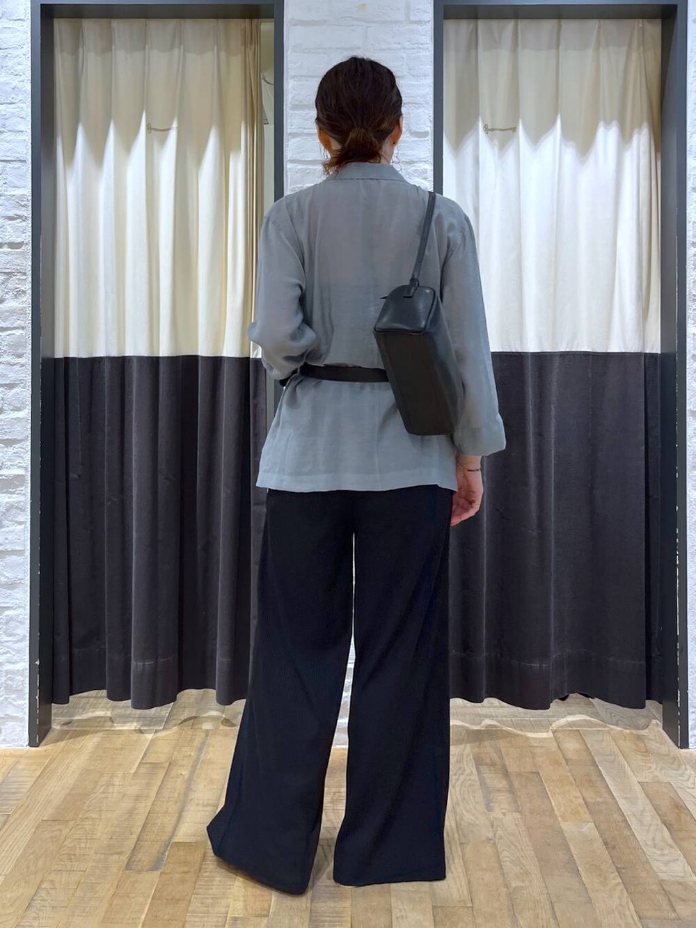 ブラック系のハンドバッグ、ブラック系のその他パンツ、ブルー系のテーラードジャケットを着用したレディースの秋コーディネートの3枚目の写真