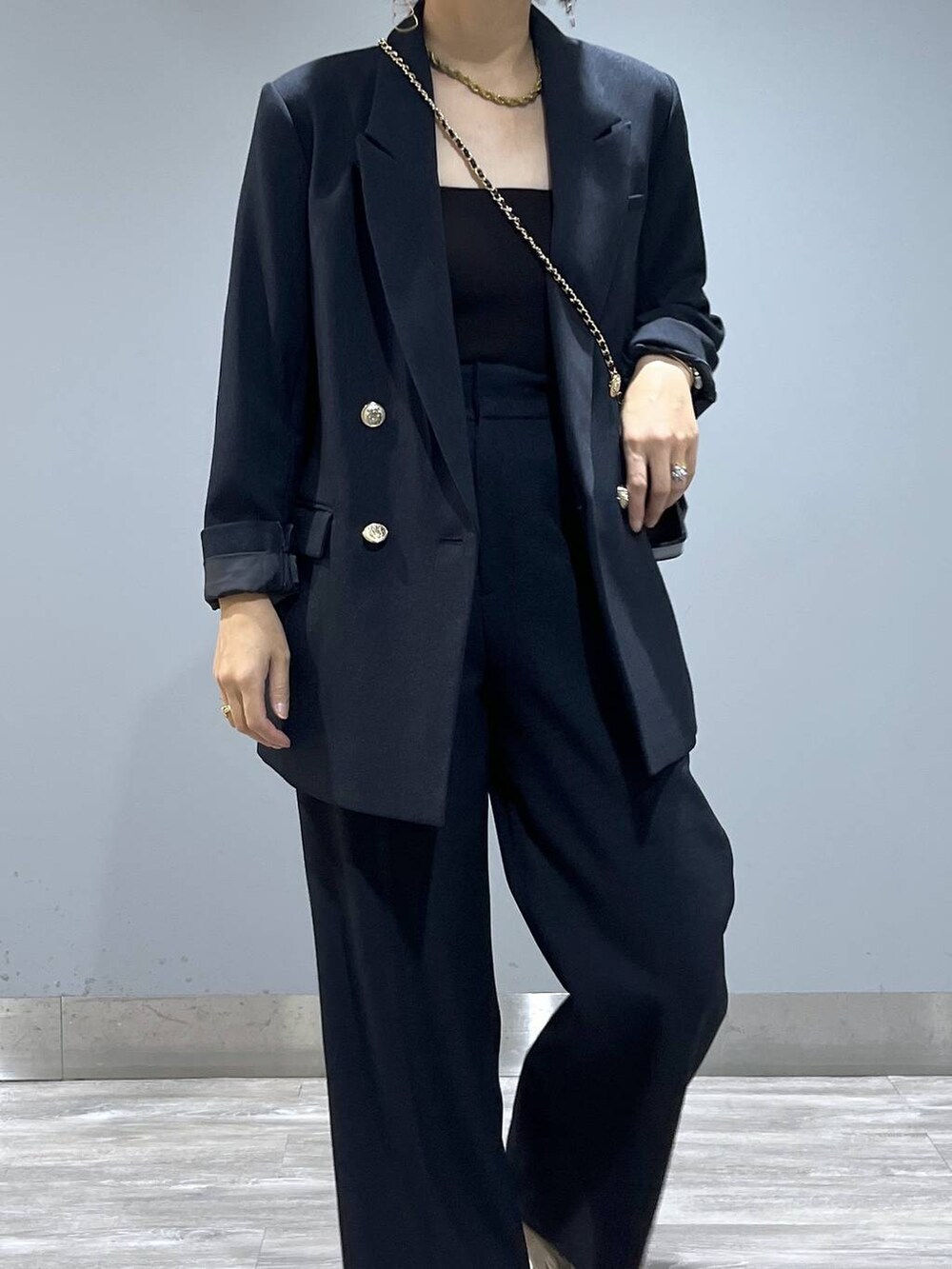 ブルー系のテーラードジャケット、ブルー系のスラックス、ベージュ系のブーツを着用したレディースの秋コーディネートの6枚目の写真