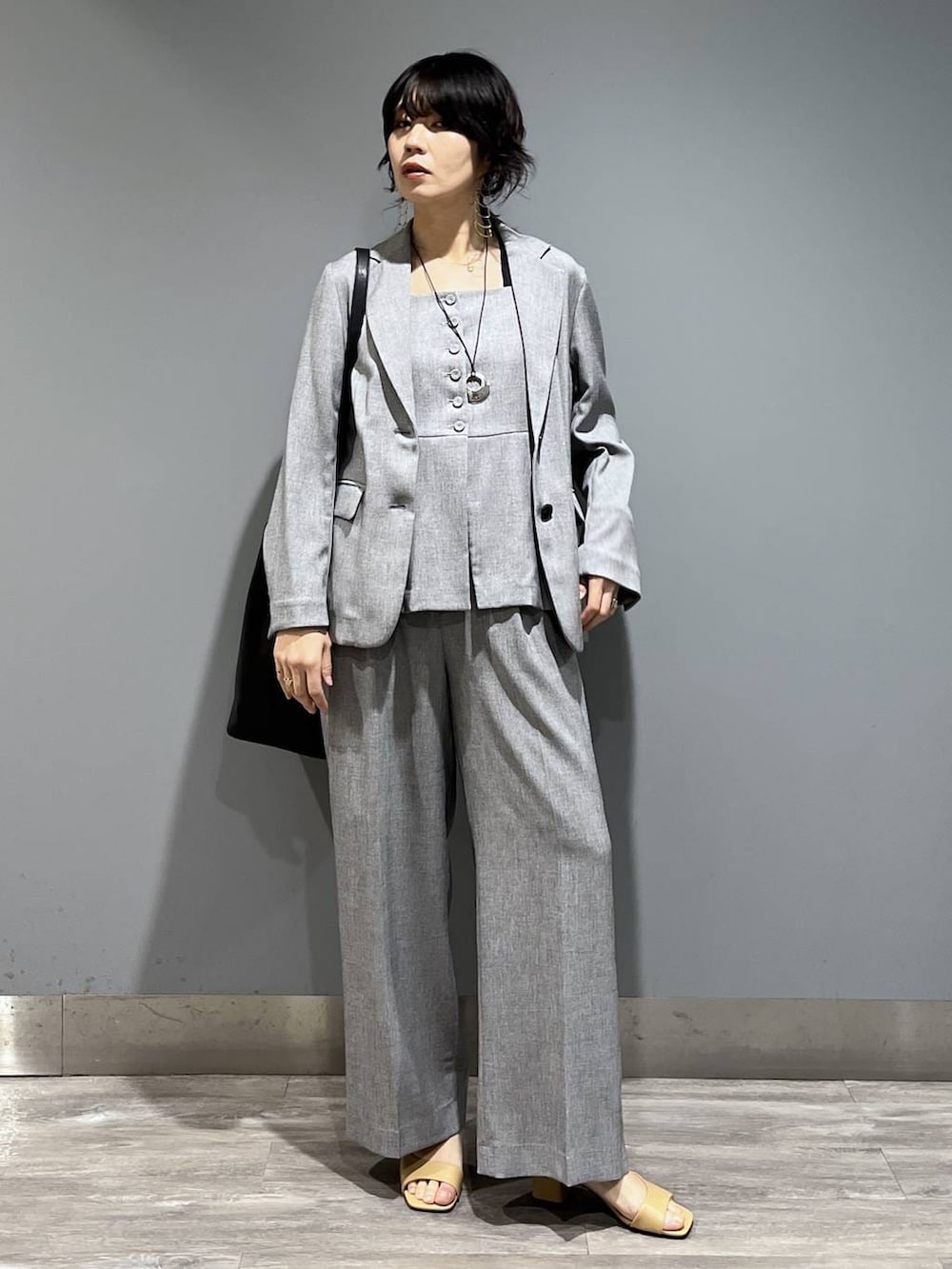 ブラック系のトートバッグ、ブラック系のノーカラージャケット、ブラック系のベストを着用したレディースの春コーディネートの8枚目の写真