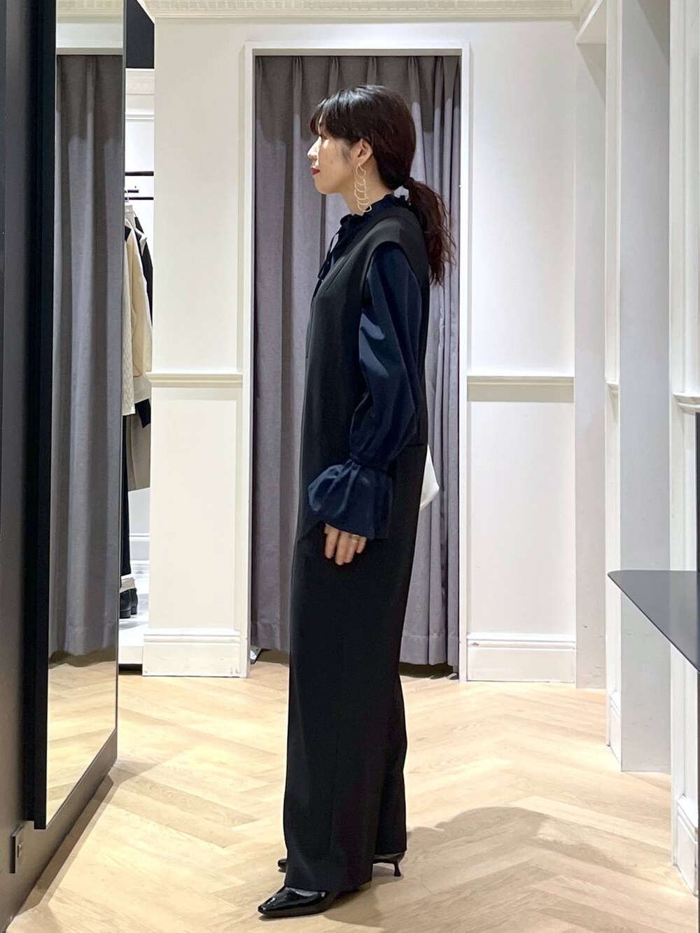 ホワイト系のショルダーバッグ、ブラック系のパンプス、ブラック系のサロペット/オーバーオールを着用したレディースの冬コーディネートの4枚目の写真