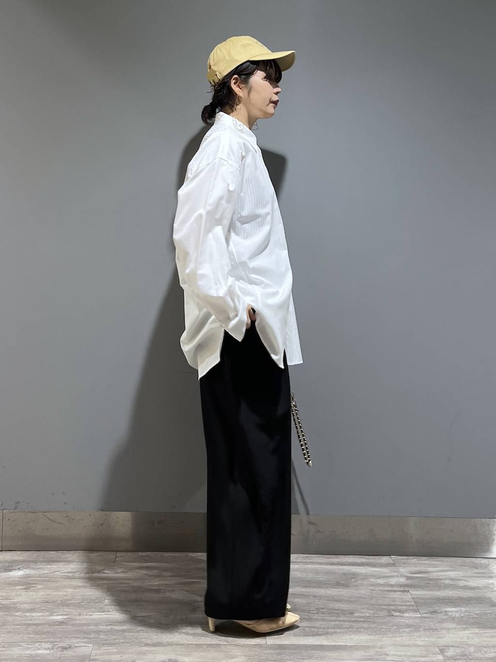 ブラック系のスラックス、ホワイト系のシャツ/ブラウス、ブラック系のショルダーバッグを着用したレディースの冬コーディネートの2枚目の写真