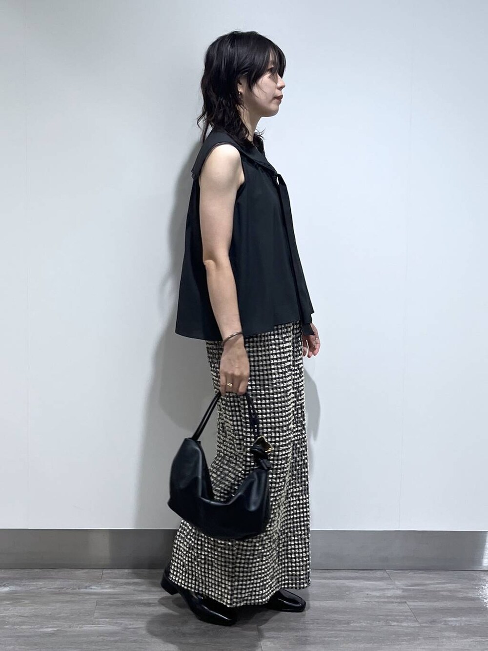 ブラック系のTシャツ/カットソー、ブラック系のローファー、ブラック系のショルダーバッグを着用したレディースの夏コーディネートの2枚目の写真