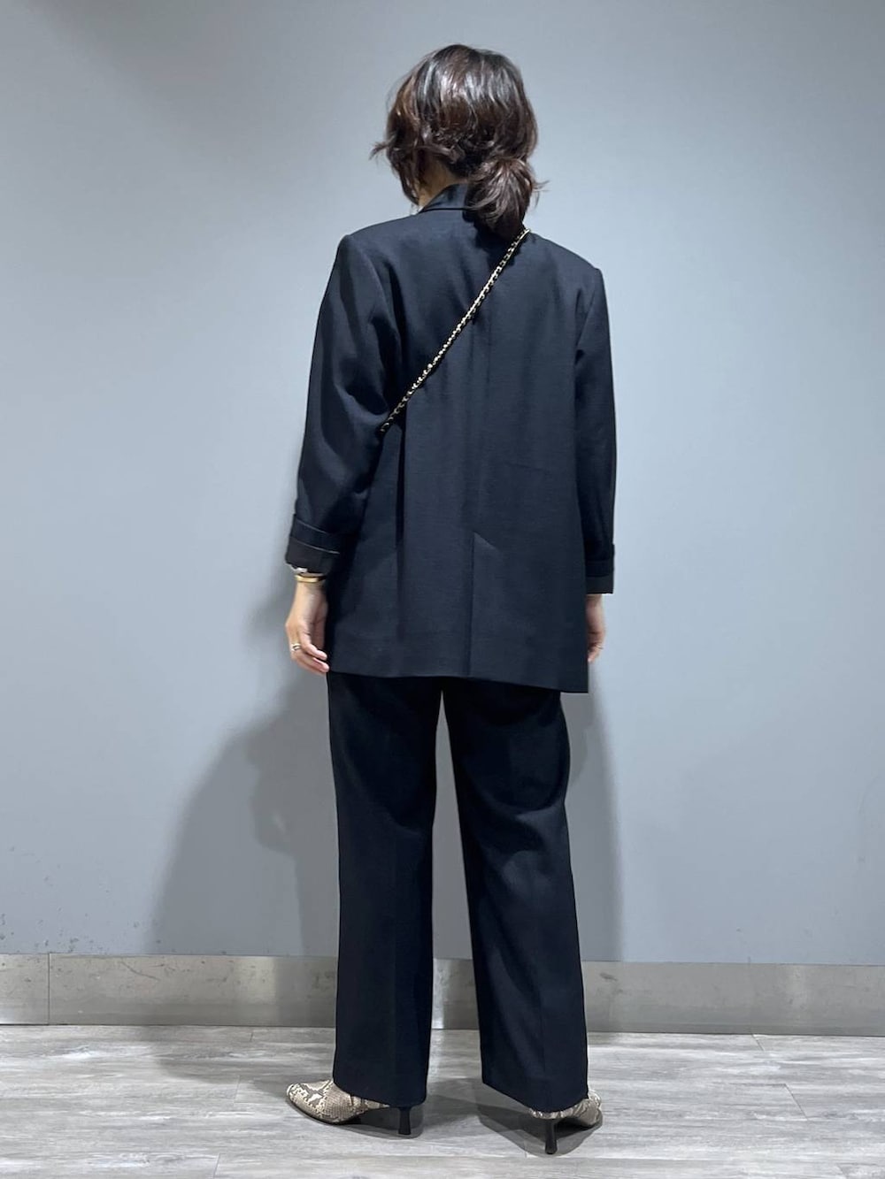 ブルー系のテーラードジャケット、ブルー系のスラックス、ベージュ系のブーツを着用したレディースの秋コーディネートの3枚目の写真