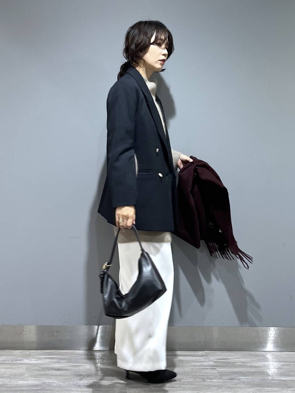 イエロー系のワンピース、ホワイト系のスラックス、ブルー系のテーラードジャケットを着用したレディースの秋コーディネートの2枚目の写真