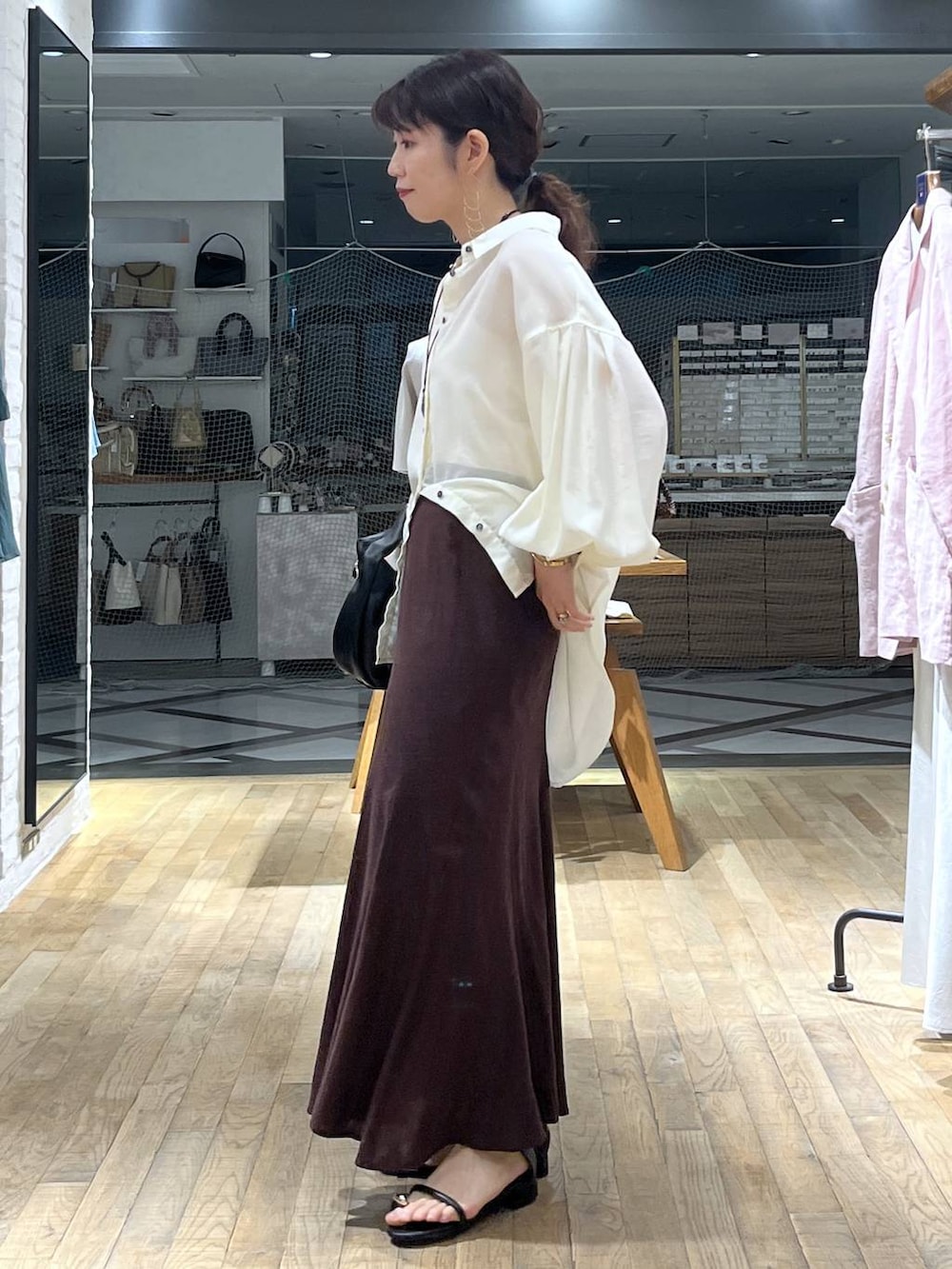 ホワイト系のシャツ/ブラウス、ブラック系のハンドバッグ、ブラック系のサンダルを着用したレディースの春コーディネートの4枚目の写真