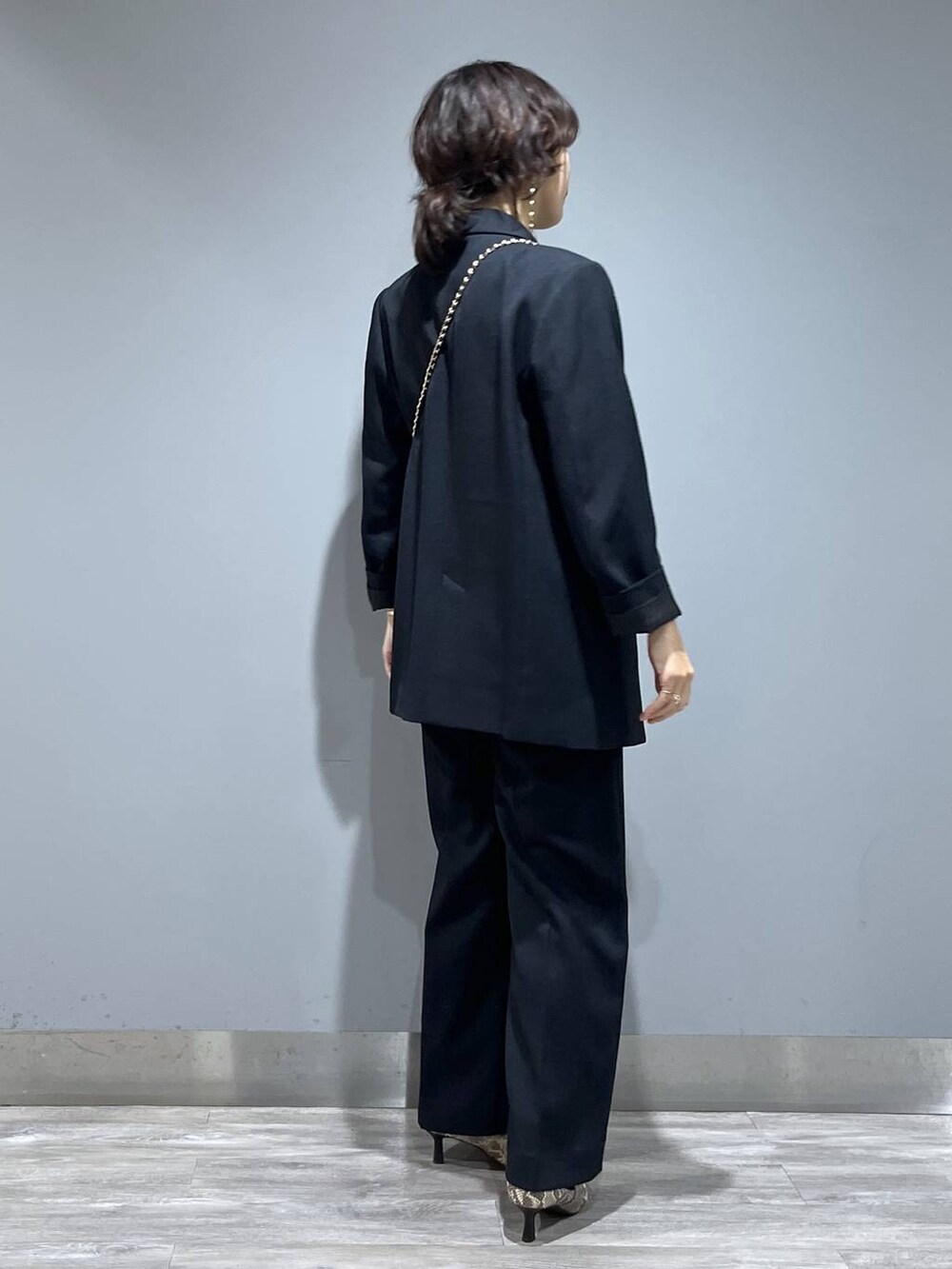 ブルー系のテーラードジャケット、ブルー系のスラックス、ベージュ系のブーツを着用したレディースの秋コーディネートの2枚目の写真