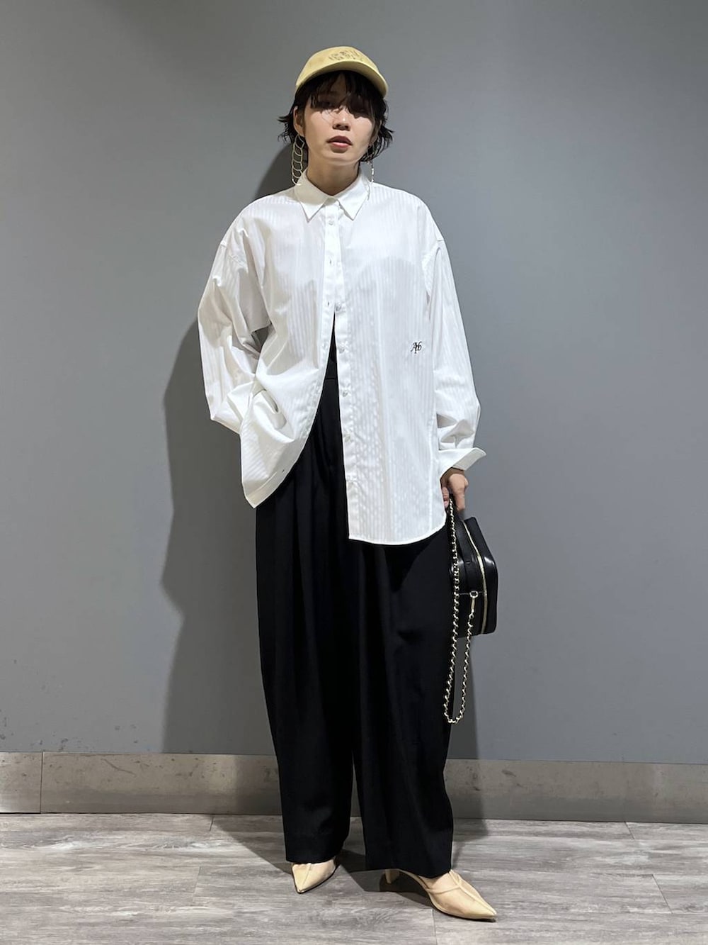 ブラック系のスラックス、ホワイト系のシャツ/ブラウス、ブラック系のショルダーバッグを着用したレディースの冬コーディネートの8枚目の写真