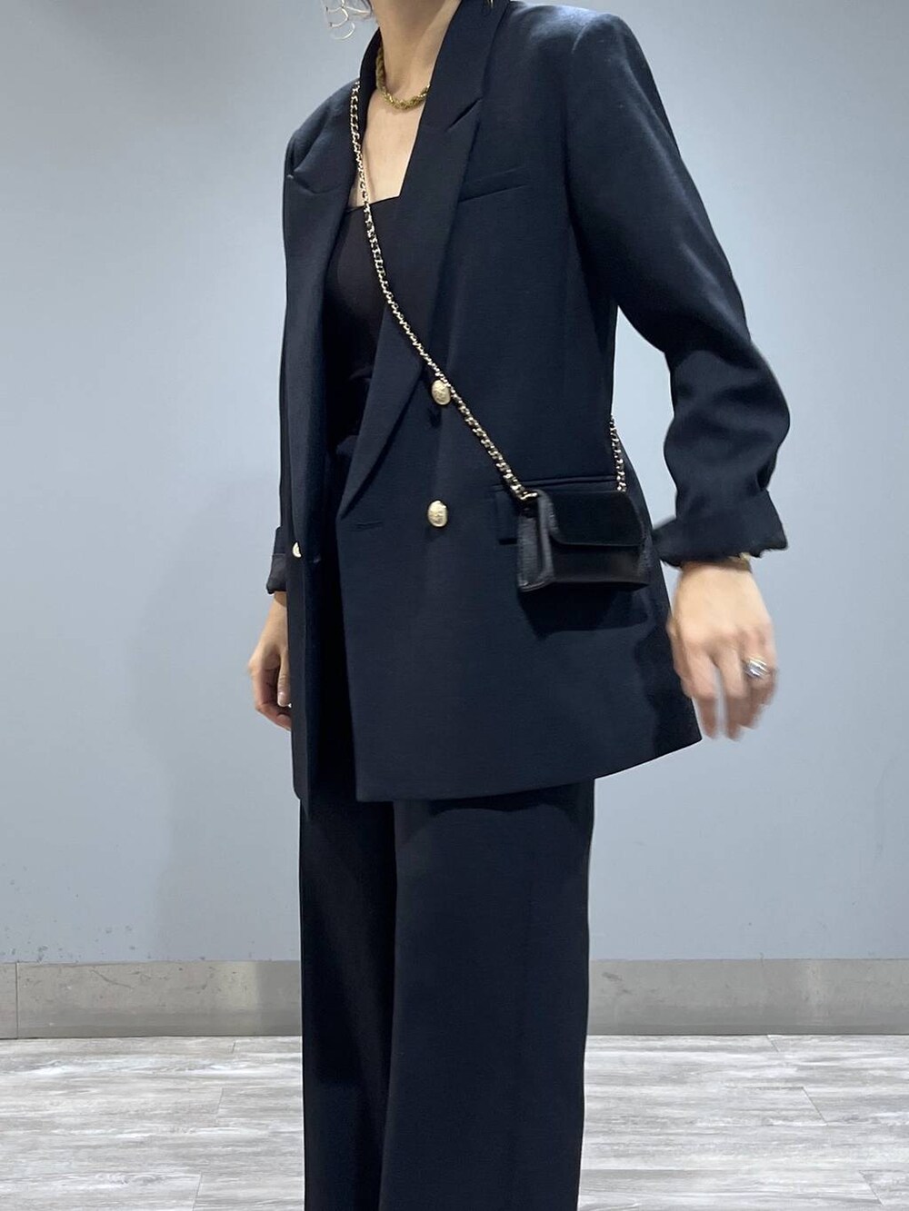 ブルー系のテーラードジャケット、ブルー系のスラックス、ベージュ系のブーツを着用したレディースの秋コーディネートの5枚目の写真