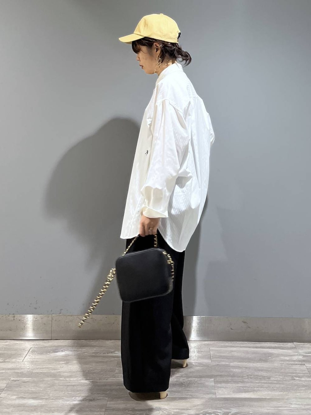 ブラック系のスラックス、ホワイト系のシャツ/ブラウス、ブラック系のショルダーバッグを着用したレディースの冬コーディネートの4枚目の写真