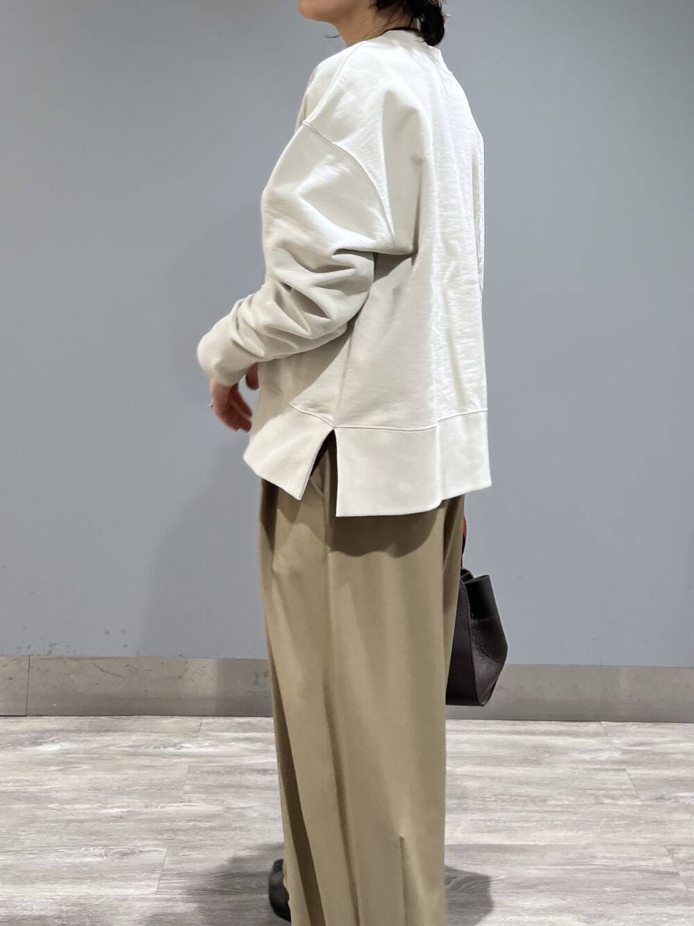 ベージュ系のスラックス、ブラック系のパンプス、ブラウン系のショルダーバッグを着用したレディースの冬コーディネートの6枚目の写真