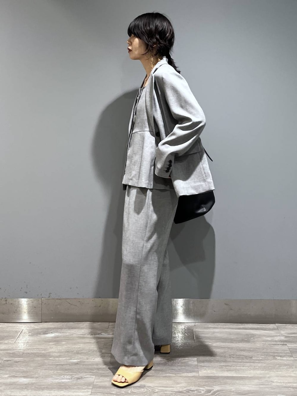 ブラック系のトートバッグ、ブラック系のノーカラージャケット、ブラック系のベストを着用したレディースの春コーディネートの5枚目の写真