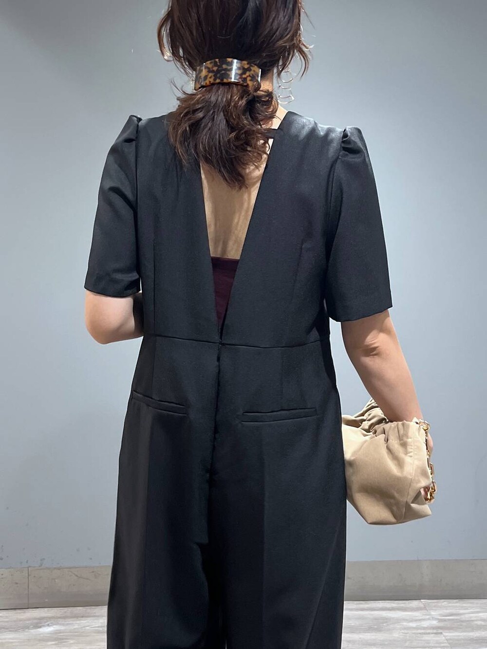 ブラック系のパンプス、ベージュ系のショルダーバッグ、ブラック系のつなぎ/オールインワンを着用したレディースの秋コーディネートの6枚目の写真