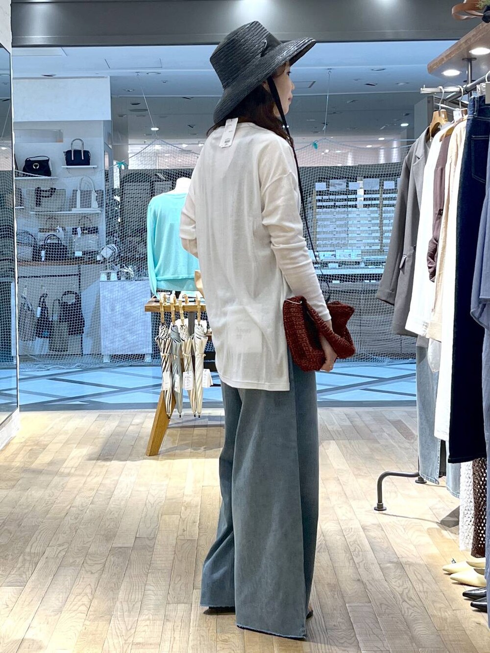 ブルー系のデニムパンツ、ブラック系のサンダル、ホワイト系のTシャツ/カットソーを着用したレディースの春コーディネートの2枚目の写真