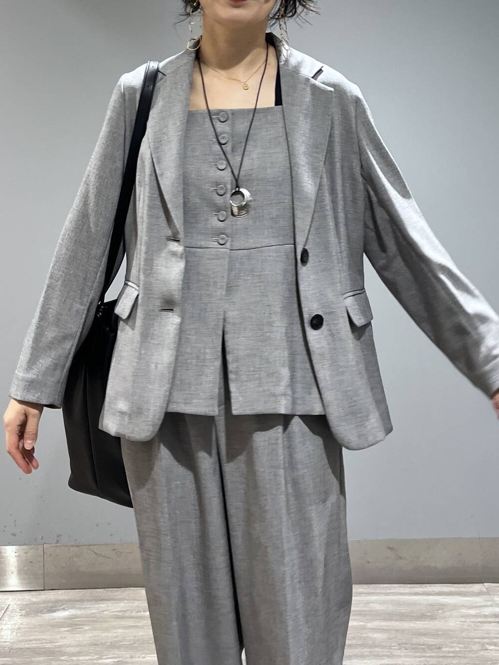 ブラック系のトートバッグ、ブラック系のノーカラージャケット、ブラック系のベストを着用したレディースの春コーディネートの7枚目の写真