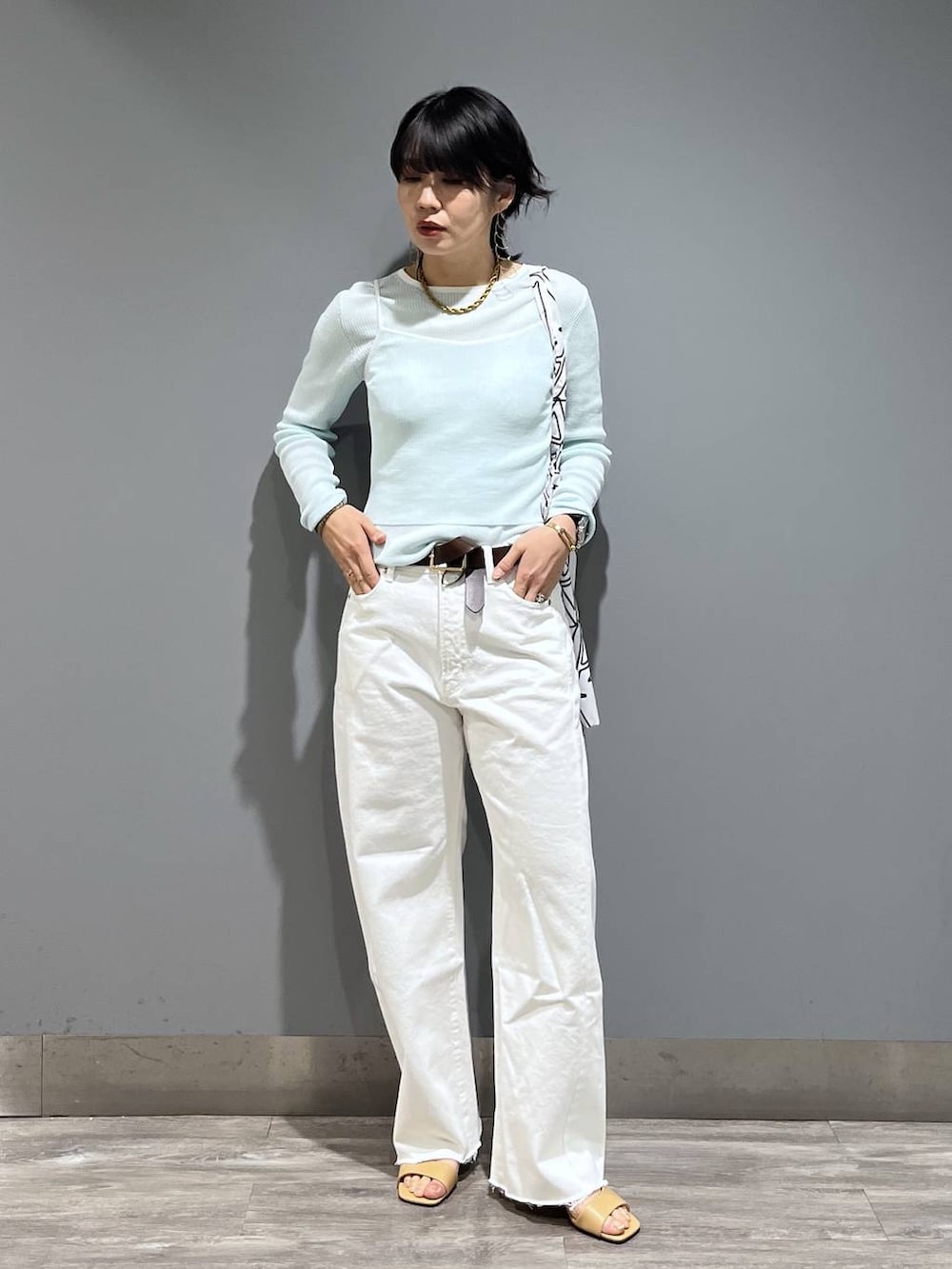 ホワイト系のデニムパンツ、ブルー系のTシャツ/カットソー、ベージュ系のサンダルを着用したレディースの春コーディネートの7枚目の写真