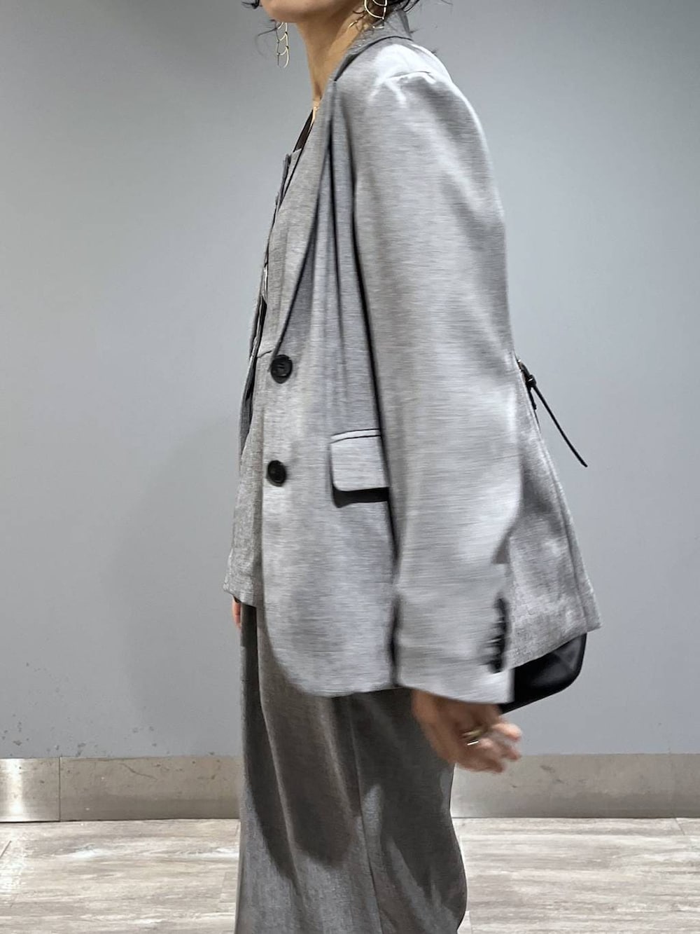 ブラック系のトートバッグ、ブラック系のノーカラージャケット、ブラック系のベストを着用したレディースの春コーディネートの6枚目の写真