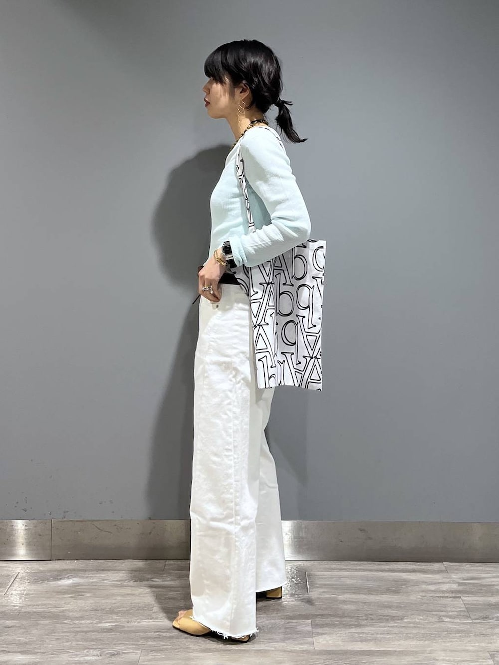 ホワイト系のデニムパンツ、ブルー系のTシャツ/カットソー、ベージュ系のサンダルを着用したレディースの春コーディネートの4枚目の写真