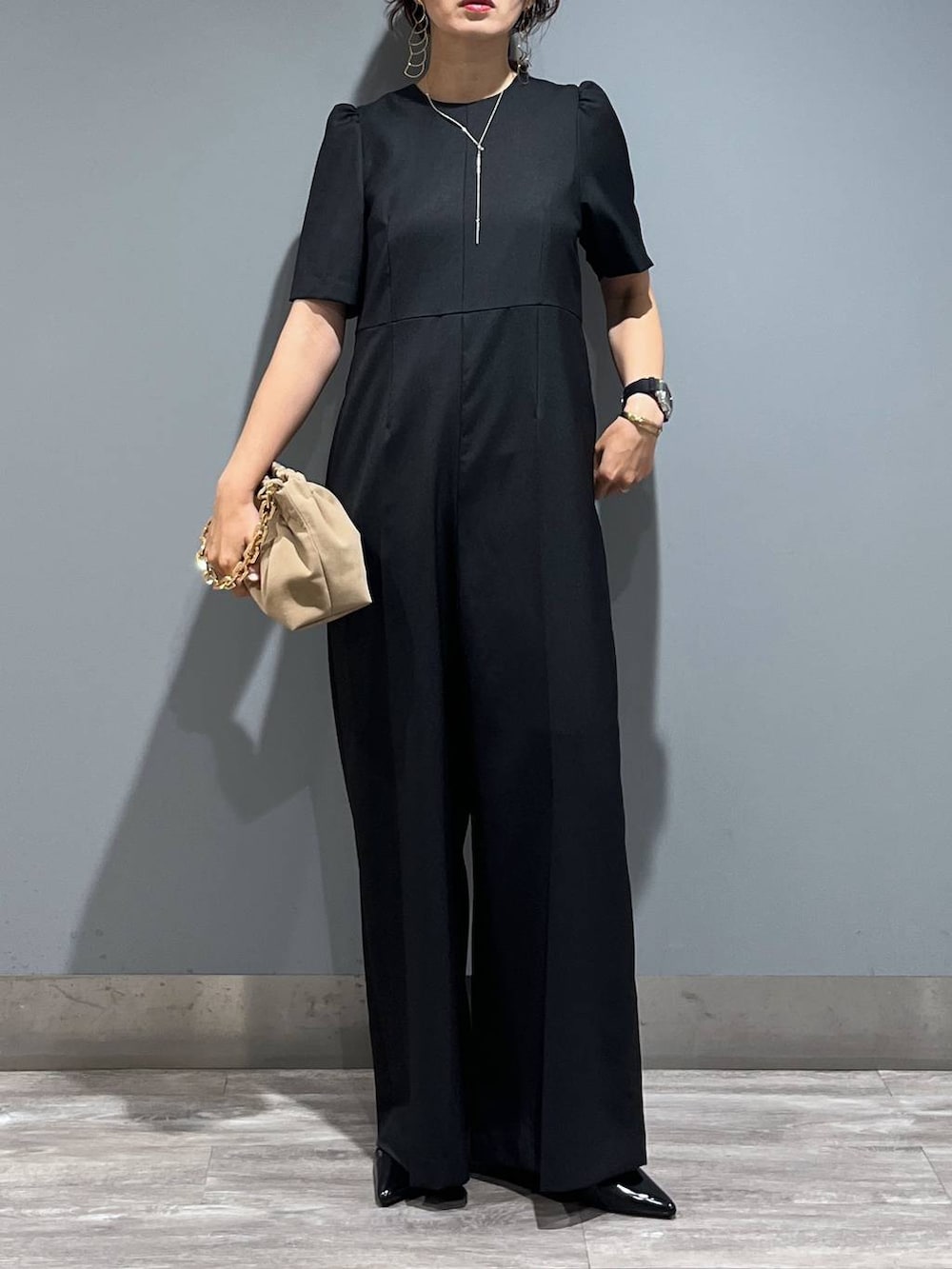 ブラック系のパンプス、ベージュ系のショルダーバッグ、ブラック系のつなぎ/オールインワンを着用したレディースの秋コーディネートの4枚目の写真