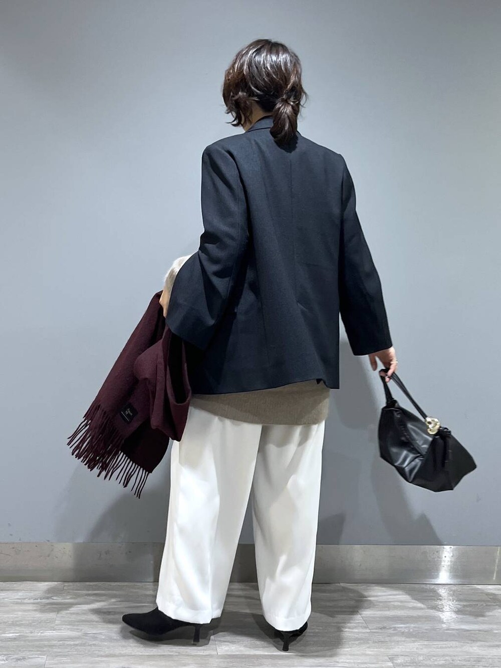 イエロー系のワンピース、ホワイト系のスラックス、ブルー系のテーラードジャケットを着用したレディースの秋コーディネートの3枚目の写真